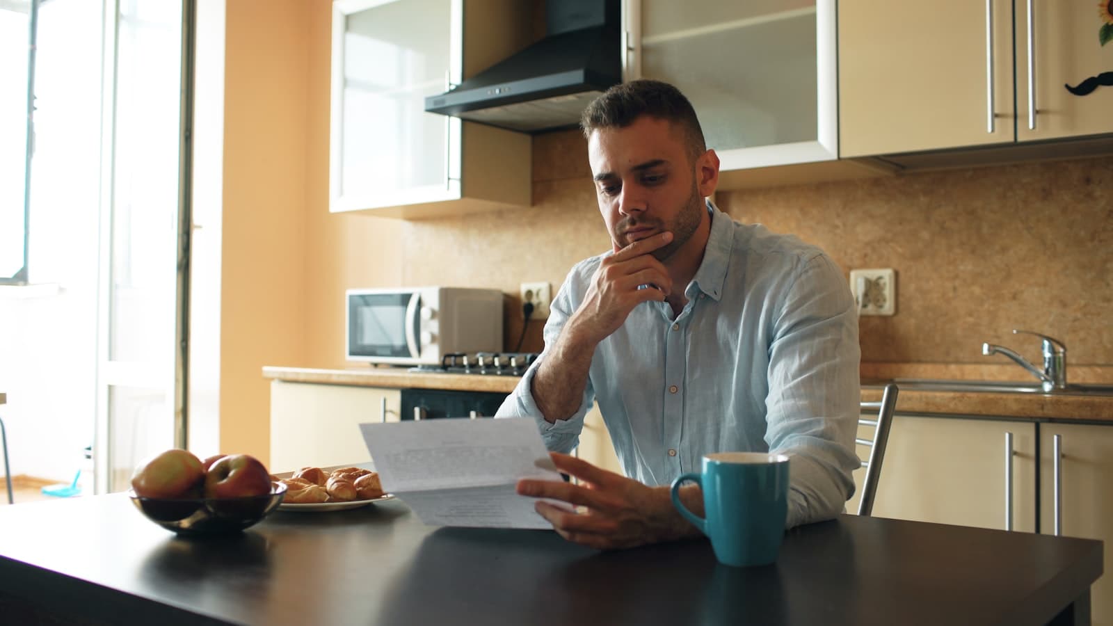 A man reading a document at his kitchen table