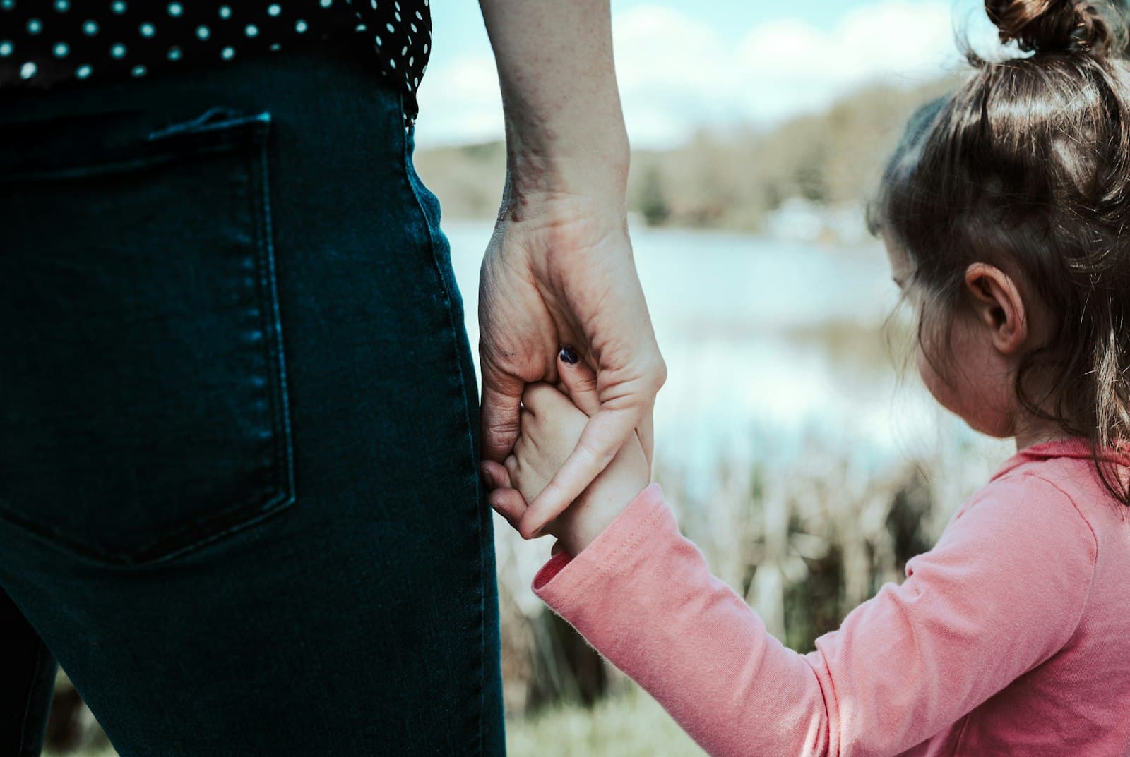 A parent holding a child's hand