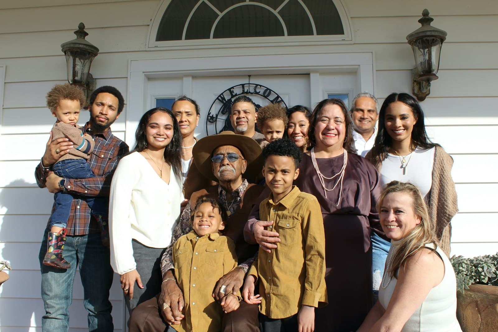 A large multigenerational family gathered together on a front porch